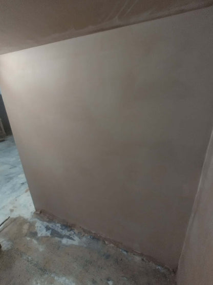 Smoothly plastered wall surface after skimming course, showcasing plaster application skills.